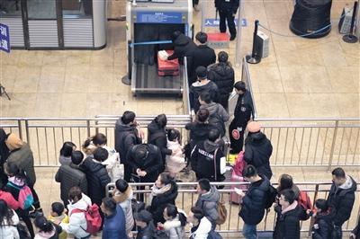 北京南站，旅客通过安检口进入候车厅