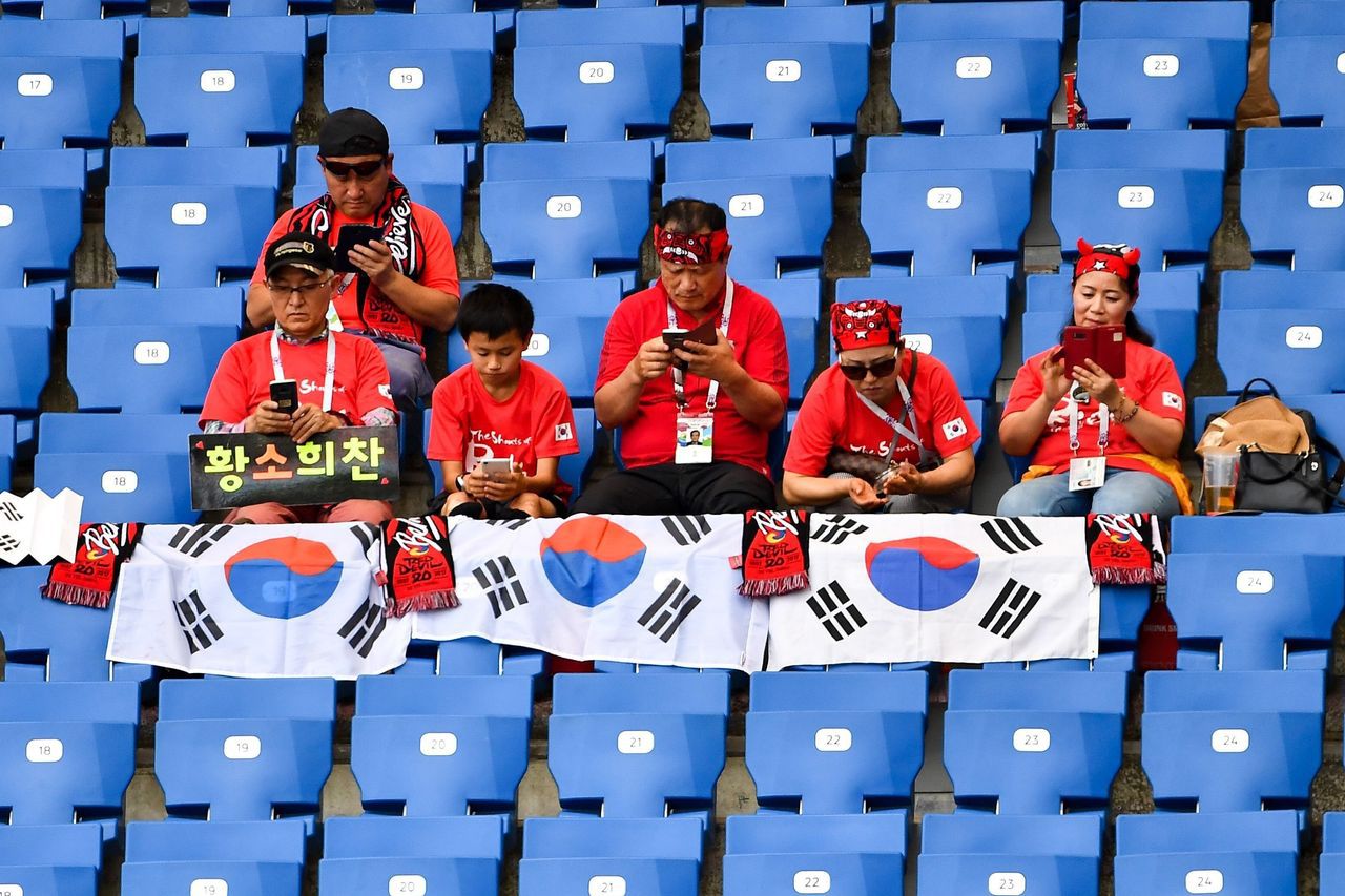 俄罗斯2018年世界杯上，韩国球迷正在看台上浏览手机
