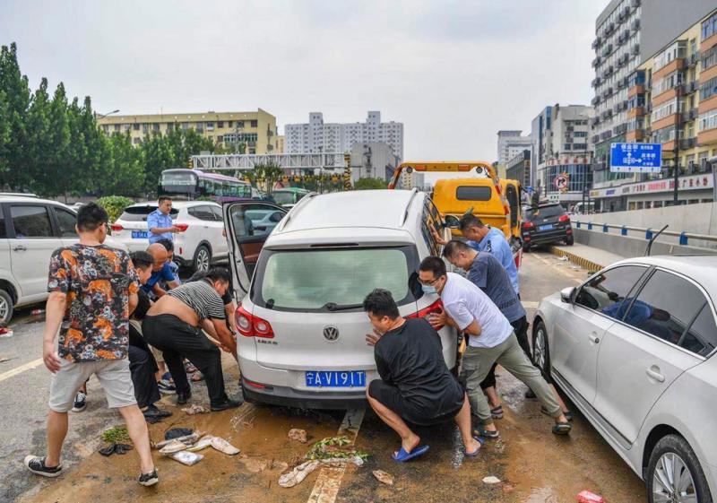 现场群众一起帮助一名宁夏车主的抛锚车辆脱困