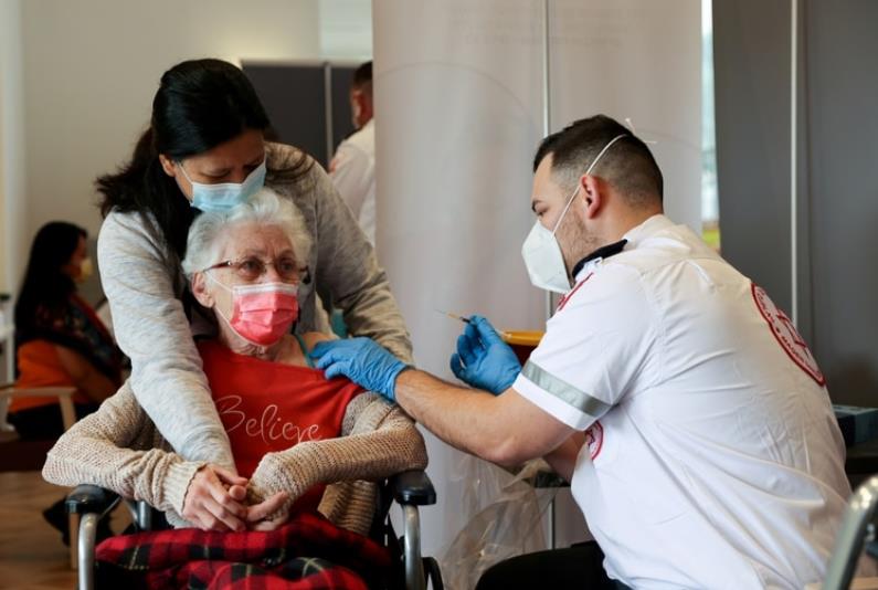 以色列医护人员1月19日替老年人施打疫苗