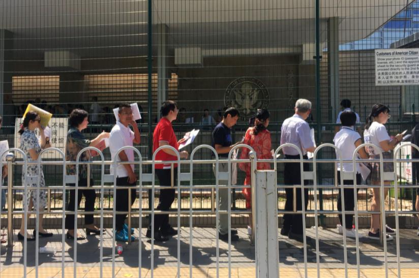 多名中国民众在美国驻华大使馆外排队等待签证