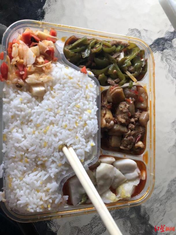 芮先生从社区工作人员那里领到的盒饭