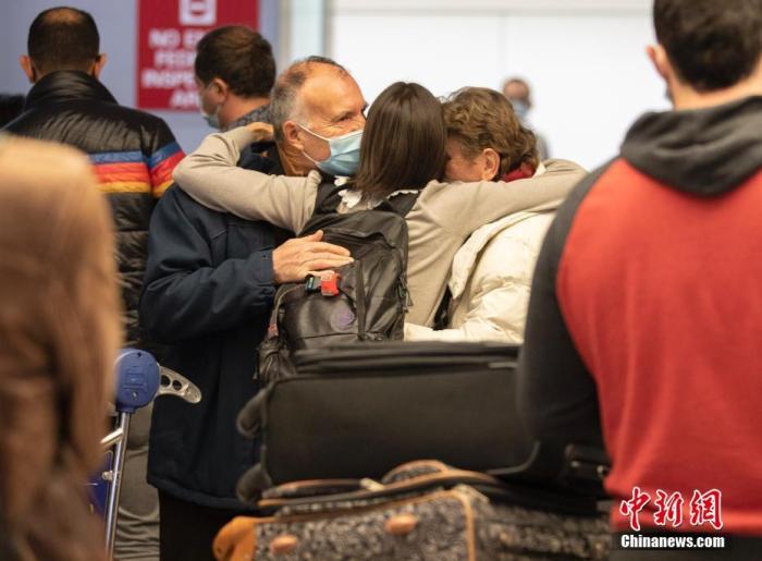 一位女士在美国加州旧金山国际机场的国际航班到达区域拥抱来自法国的父母 ...