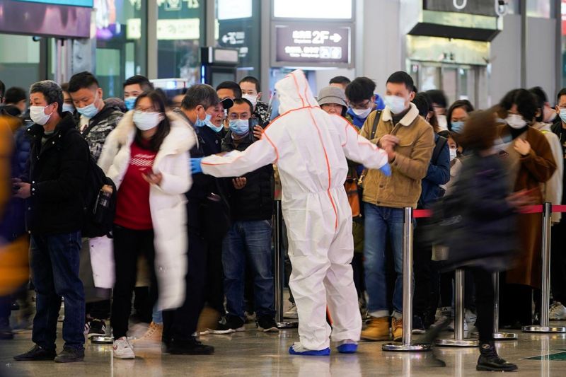   上海虹桥火车站一名安检员指示人们扫描健康码