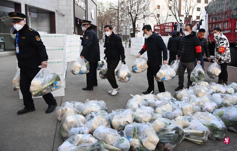 西安市新城区西一路街道办事处人员上月29日在搬运配送居民的免费生活物资 ...