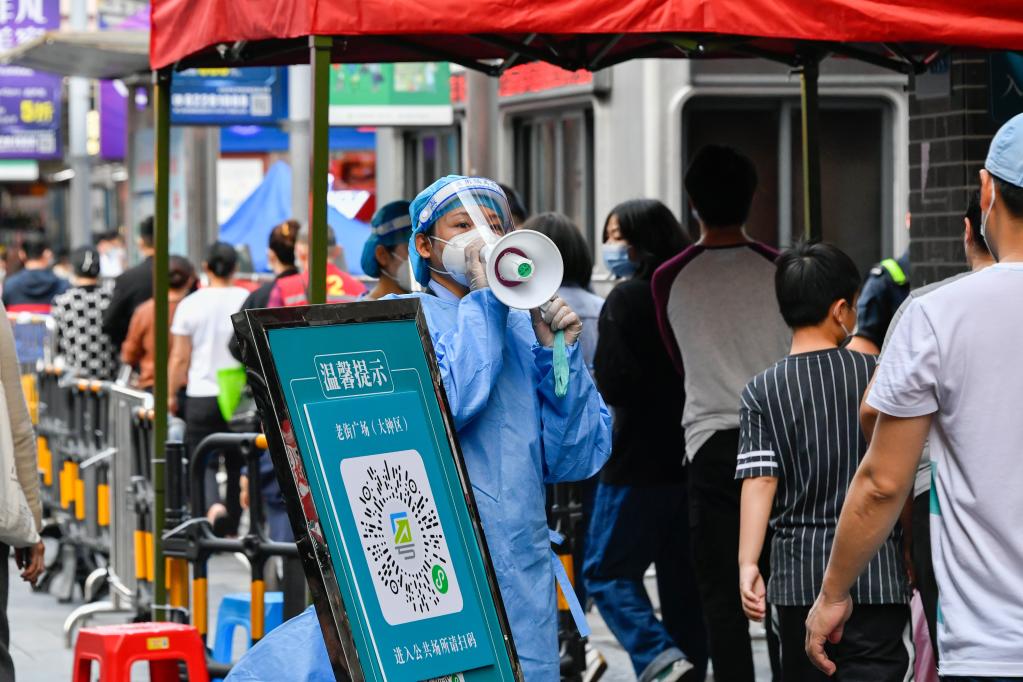 志愿者在深圳罗湖区东门广场核酸检测点引导居民