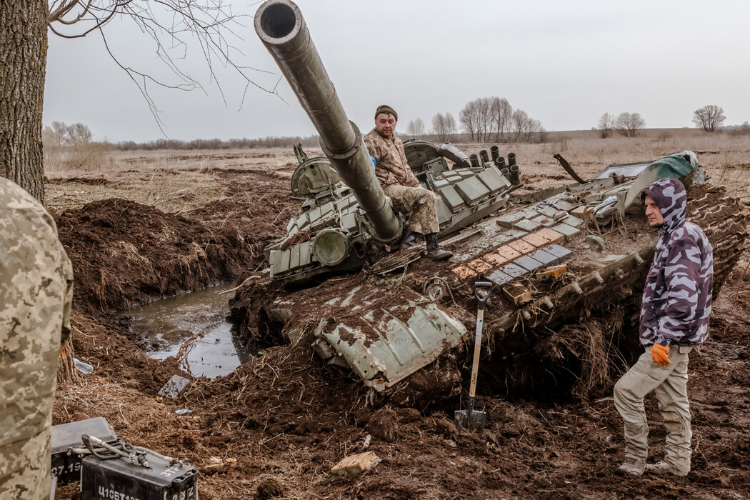 乌克兰士兵站在一辆废弃的俄军坦克旁