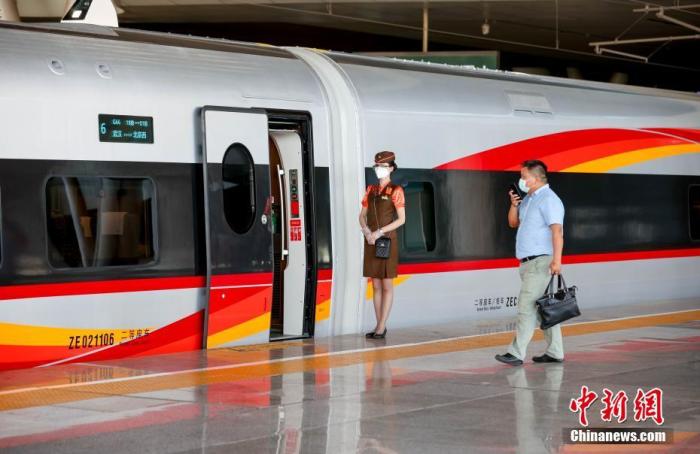 武汉开往北京西的G66动车组列车乘务员正在迎接旅客上车