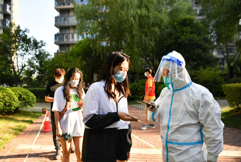 志愿者（右一）为西安市曲江新区紫汀苑社区居民进行核酸检测信息登记