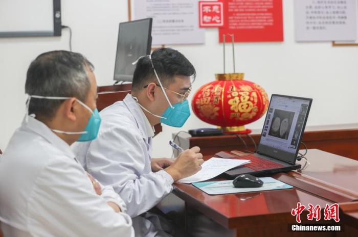 两位急诊科医生在ICU会议室内参与远程会诊