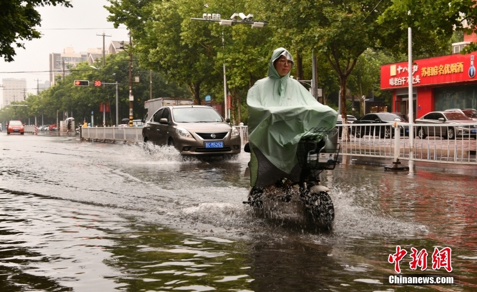 市民在石家庄市栾城区街头冒雨出行