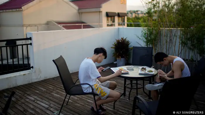 两名青少年于中国上海的咖啡厅内使用手机上网。