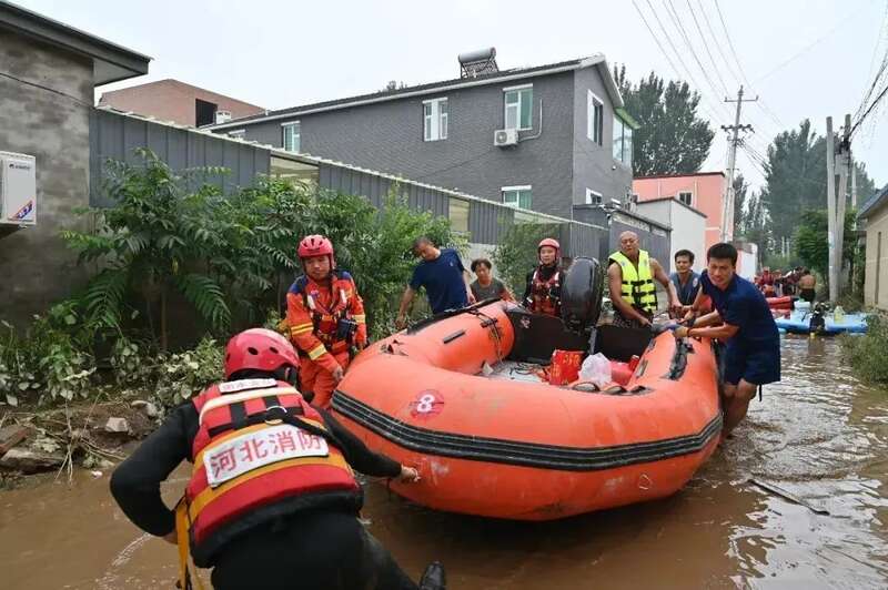 救援人员在涿州转移受灾群众