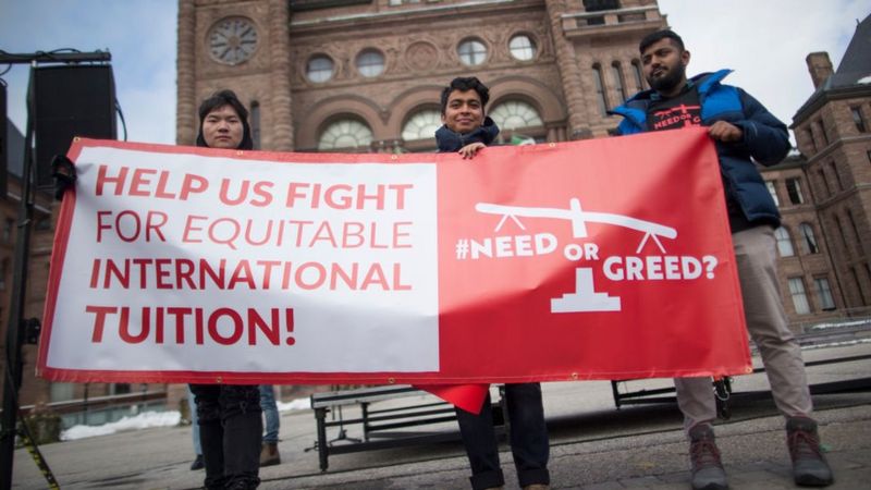 一群在加拿大的国际学生及其支持者手持标语，呼吁人们关注该群体面临的几个问题 ...